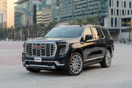 GMC Yukon luxury SUV with chauffeur parked in Dubai business district for premium transfer service