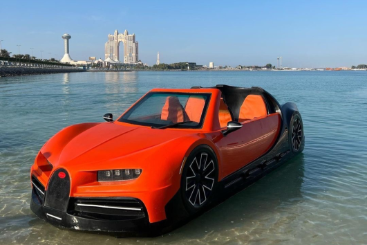 Orange jet car floating on the water in Abu Dhabi with Nation Towers in the background