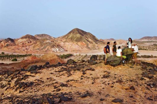 Group nature walk across rocky desert terrain at Sir Bani Yas Island
