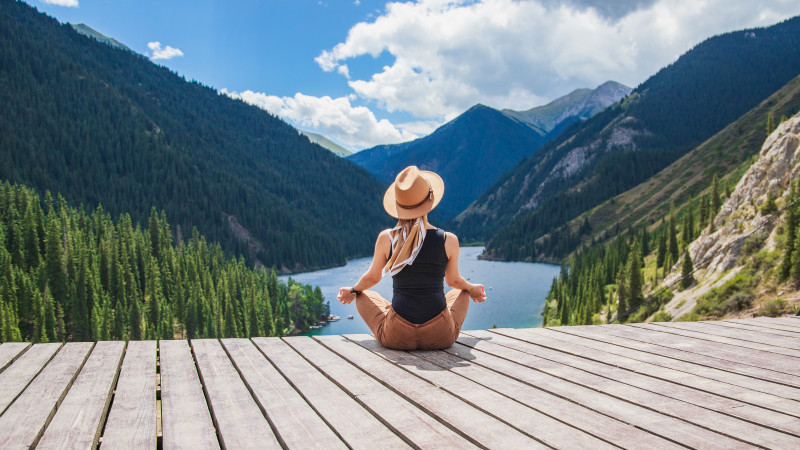 Traveler meditating at lake viewpoint in Almarasan Gorge Almaty