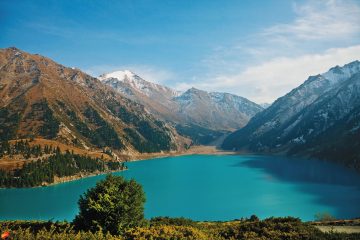 Big Almaty Lake surrounded by mountains under a blue sky in Kazakhstan