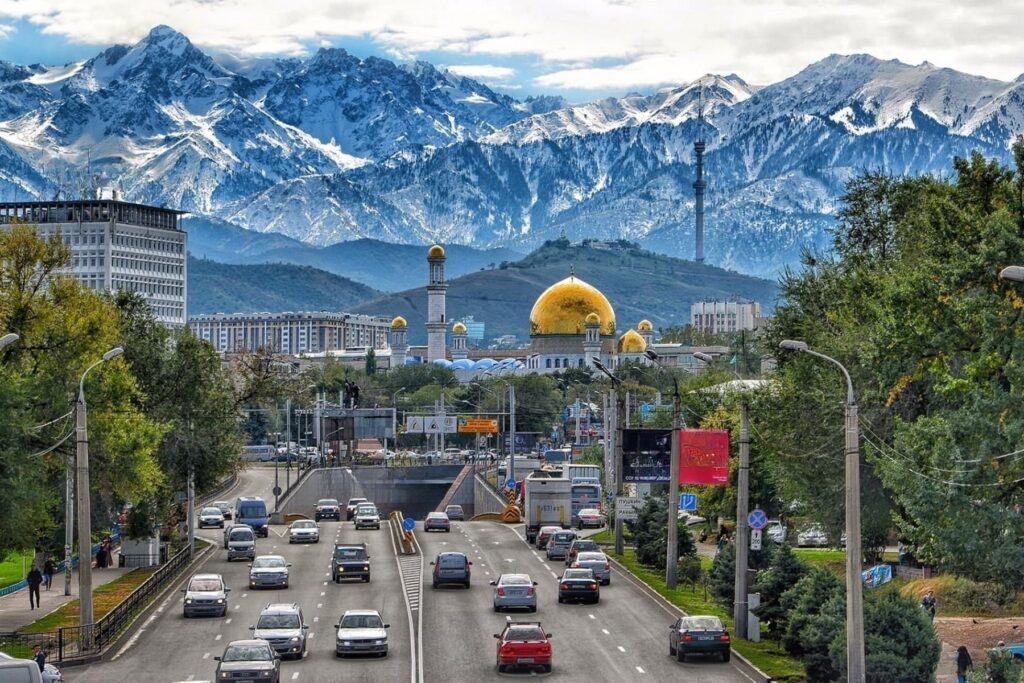 Almaty city skyline with mosque and snow-capped mountains in background