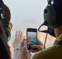 Passenger taking photos from inside a helicopter over Dubai coastline