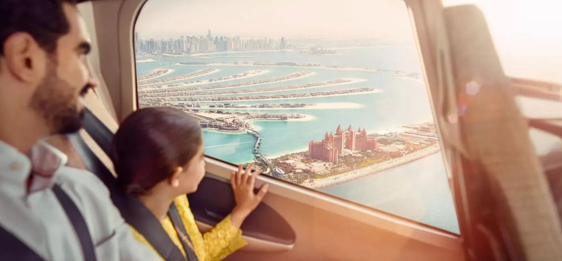 Family and child looking out of a helicopter window at Palm Jumeirah and Atlantis The Palm in Dubai