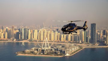 Helicopter flying over Bluewaters Island and Ain Dubai observation wheel