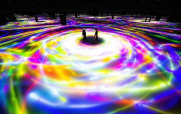 large abstract light projections on geometric structures outdoors at night