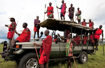 Maasai tribe members standing on safari jeep in Kenya