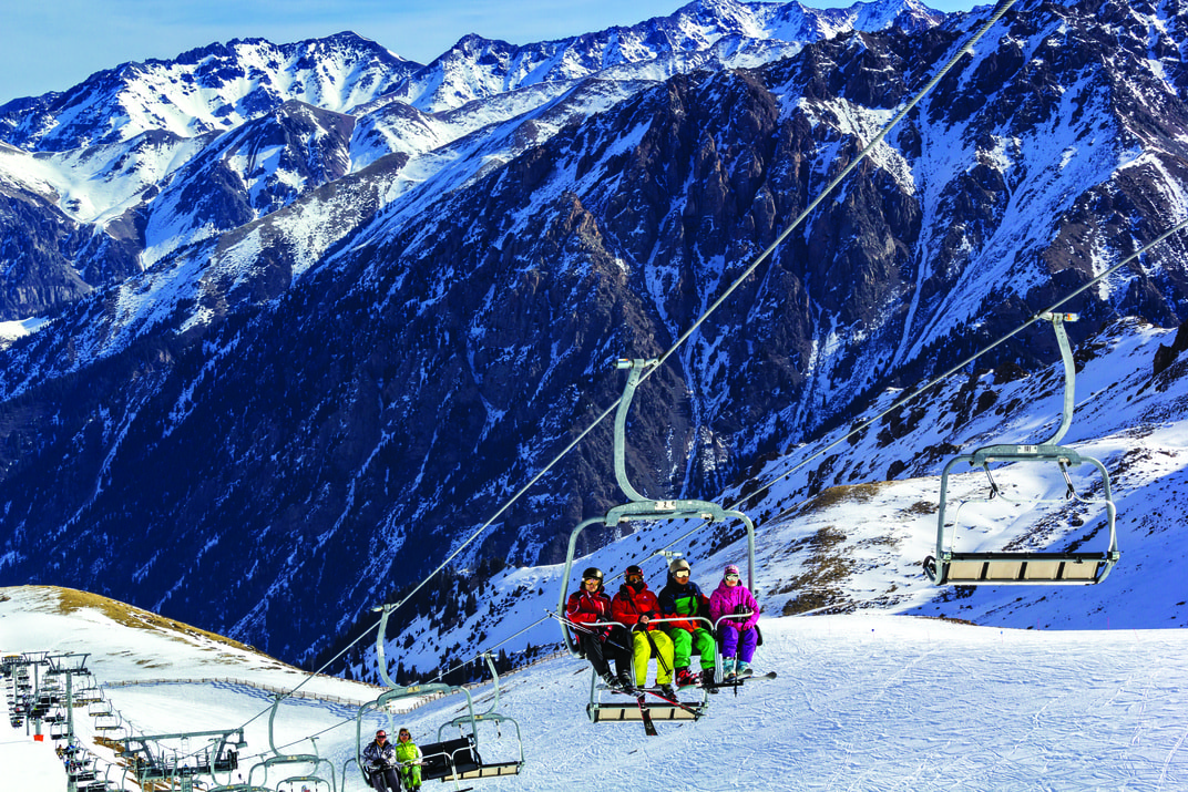 Skiers on chairlift at Shymbulak Ski Resort in Tien Shan mountains