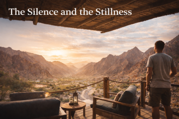 Man standing on eco-lodge balcony overlooking Hatta valley and mountains