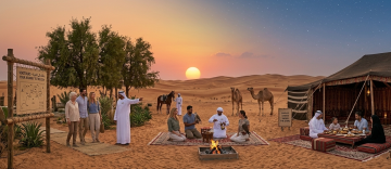 Guests enjoying Bedouin dinner, falcon interaction, and camel encounters at sunset in Abu Dhabi desert camp