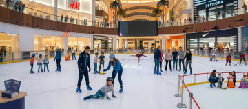 wide view of Dubai Ice Rink with colorful lights and crowd skating Dubai Mall
