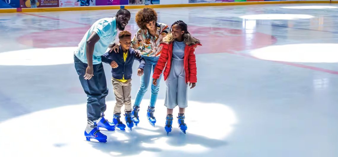 family ice skating together parents and kids enjoying Dubai Ice Rink indoor skating
