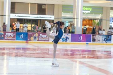 young girl performing figure skating pose indoor Dubai Ice Rink