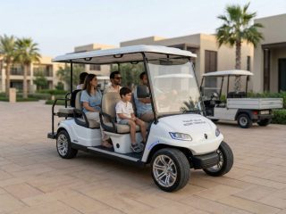 family riding electric golf cart in modern residential community with villas