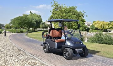 luxury golf cart driving on landscaped pathway in residential area