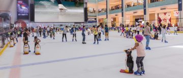 large group of people ice skating inside Dubai Mall rink