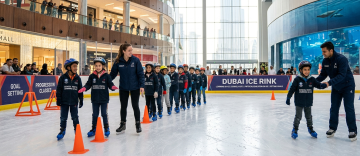 school students learning ice skating with instructor Dubai Ice Rink educational visit
