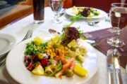 Plated salad with fresh vegetables and olives, served onboard a dhow.