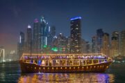 Dhow cruise passing Dubai skyscrapers at night