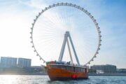 Dhow boat cruising past Ain Dubai, the world’s largest observation wheel.