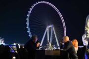 Guests dining on the upper deck with Ain Dubai illuminated in the background.