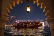 View of the dhow cruise framed by a traditional Arabian arch at night.