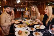 Guests enjoying dinner and conversation aboard the dhow cruise.