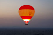 Hot air balloon soaring over Dubai's desert at sunrise