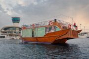 Traditional wooden dhow anchored at Yas Marina, Abu Dhabi, ready for a sightseeing cruise.