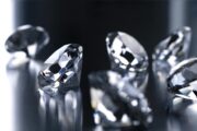 Close-up of several sparkling diamonds on a reflective surface