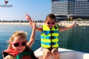 Kids enjoying a boat ride near a luxury hotel