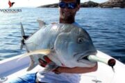 Fisherman holding a giant fish aboard a boat