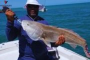 Fisherman displaying a large catch of the day on the open sea.