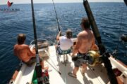 Group of friends enjoying deep-sea fishing on a private boat.