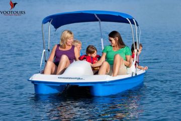 Family enjoying a canopy-shaded pedal boat ride in Ras Al Khaimah.