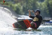 Person wakeboarding with determination and balance.