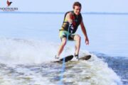 A man enjoying water skiing, smiling as he glides smoothly over the water.