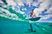 A split-view shot capturing an e-Foil rider gliding above water with underwater visibility.