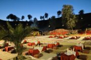 Beautifully lit desert camp recreation area at dusk with traditional seating arrangements.