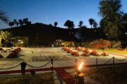 Beautifully lit desert camp recreation area at dusk with traditional seating arrangements.