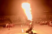 Performer breathing fire during a nighttime entertainment show in a desert camp