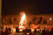 Fire dancer performing a fiery spectacle during a desert camp evening show.