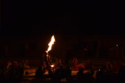 Fire performer exhaling a large flame during a desert camp show