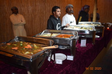 Chef serving a traditional BBQ platter at a desert camp.