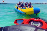 Group of friends enjoying a Banana Bus ride on crystal-clear waters.