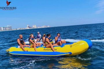 Tourists on a Banana Bus ride with a stunning coastal backdrop.