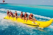 Thrill-seekers having fun on a banana ride in crystal-clear waters