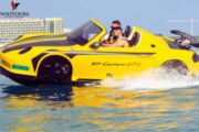 A sleek yellow jet car cruising on calm blue waters under the sun.