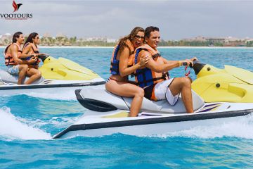 Couples enjoying an exciting double jet ski ride on vibrant yellow jet skis across turquoise waters.