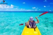 Single kayaker on crystal-clear turquoise water